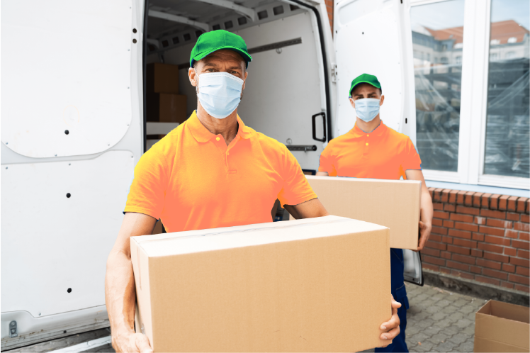 two man posing to the camera with boxes near a van