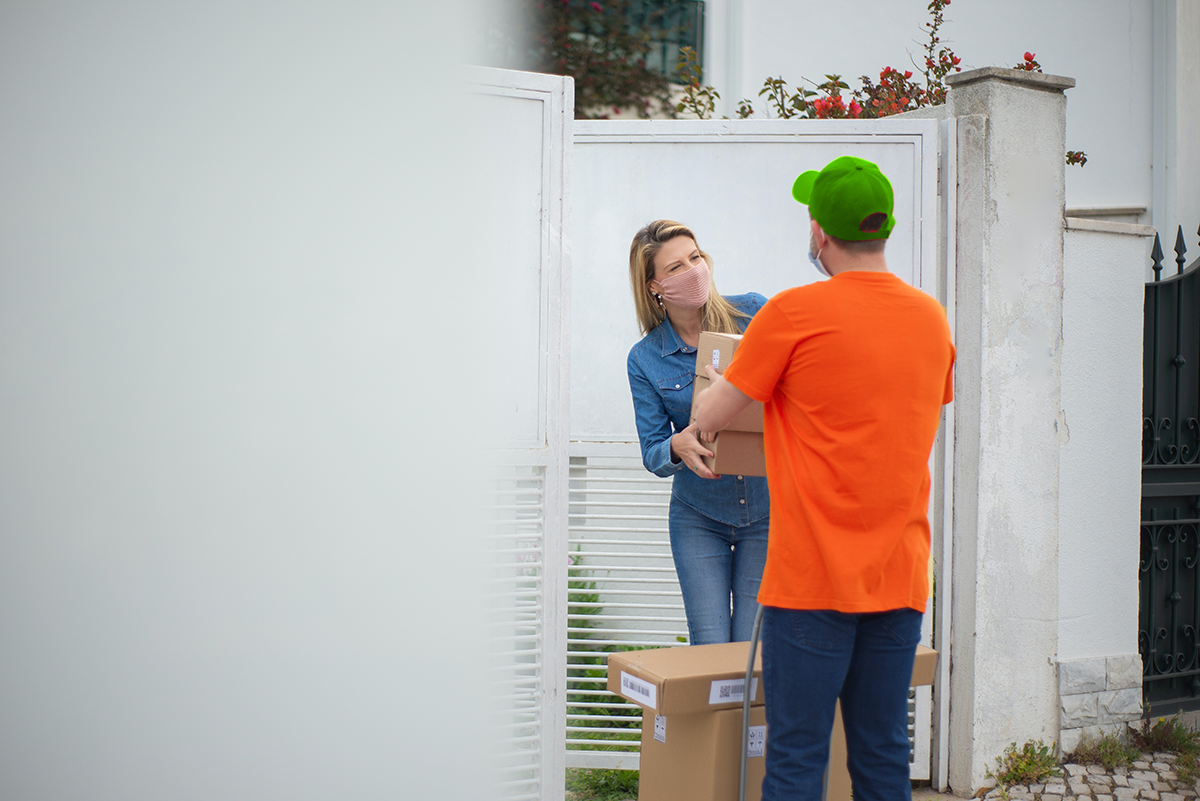 a delivery man giving out a box to a happy woman