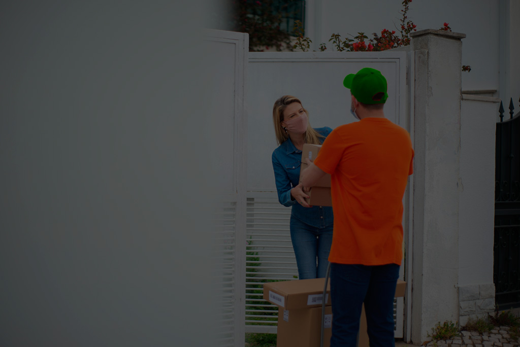 a delivery man handling a package to a woman