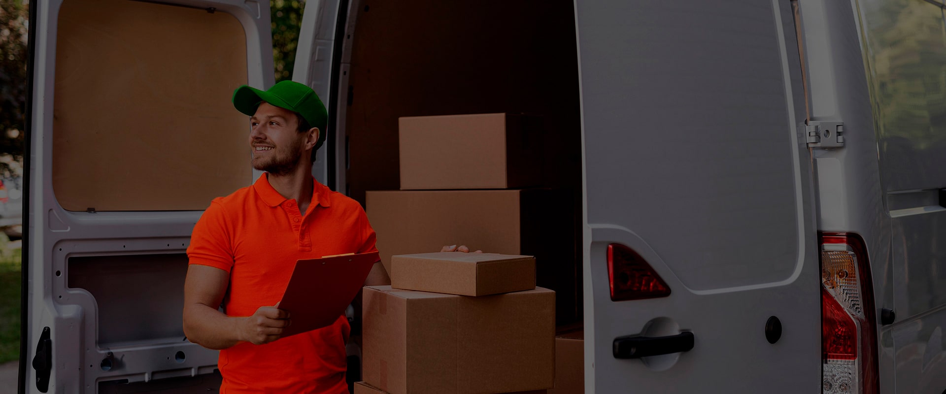 A delivery man unloading boxes from his van